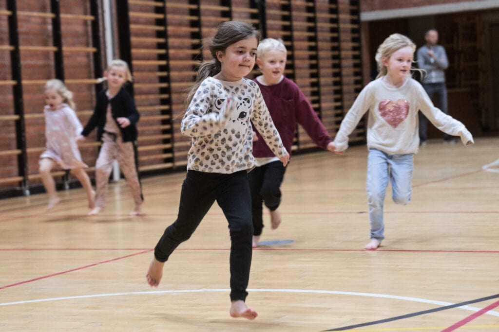 Børn der leger i en idrætshal