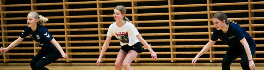 3 piger laver øvelser i gymnastiksal