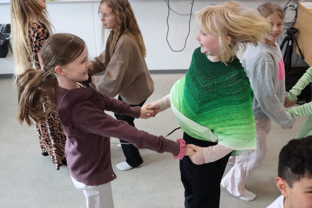 To børn med hinanden i hænderne hopper